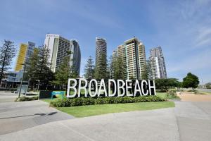 a sign in front of a city with tall buildings at Oracle 2 1907 in Gold Coast