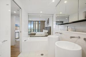 a white bathroom with a tub and a sink at Oracle 2 1907 in Gold Coast