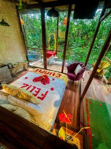 Puyu Glamping في Tarqui: سرير في غرفة مطلة على غابة