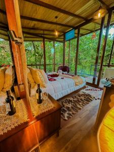 um quarto com uma cama num quarto com árvores em Puyu Glamping em Tarqui