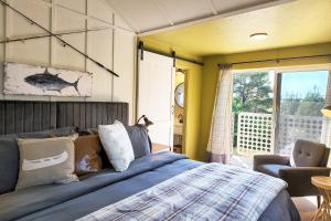 Un dormitorio con una cama y una silla y una ventana. en Alsea Shores! Dog Friendly and Hot Tub!, en Waldport