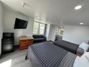 a bedroom with two beds and a flat screen tv at Motel Santa Cruz in Santa Cruz