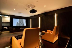 a living room with two chairs and a flat screen tv at Oracle 2 1907 in Gold Coast