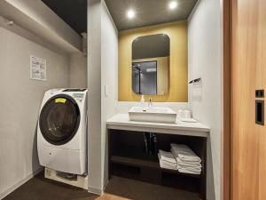 La salle de bains est pourvue d'un lave-linge et d'un lavabo. dans l'établissement MIMARU KYOTO NIJO CASTLE , à Kyoto