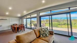 a living room with a couch and a table at Beachside Beauty in Caves Beach