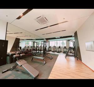 a gym with several treadmills and machines in a room at Twentyfive7 Amber Residence in Shah Alam
