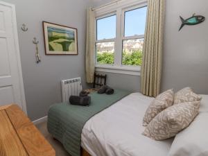 een slaapkamer met een bed en een raam bij 8 Rosewall Cottages in St Ives