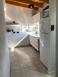 a kitchen with a white refrigerator and a tile floor at Departamento vista de montaña in Las Heras
