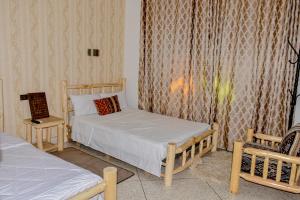 1 dormitorio pequeño con 2 camas y 1 silla en Hotel Safari Week-end, en Midelt