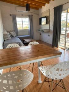 a living room with a table and white chairs at Departamento vista de montaña in Las Heras +16 photos