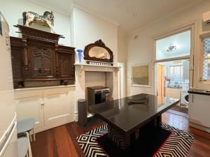 a kitchen with a black table and a fireplace at Subiaco 1bd In Heritage Home Gem in Perth