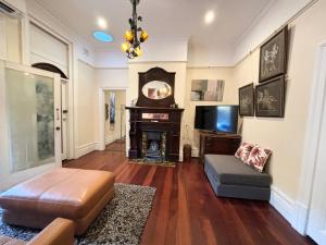 a living room with a fireplace and a tv at Subiaco 1bd In Heritage Home Gem in Perth