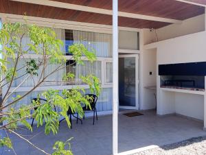 ein Haus mit einer Terrasse mit Stühlen und einem Tisch in der Unterkunft Las Acacias suites in San Lorenzo