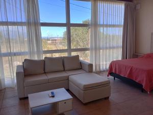 ein Wohnzimmer mit einer Couch und einem Bett in der Unterkunft Las Acacias suites in San Lorenzo