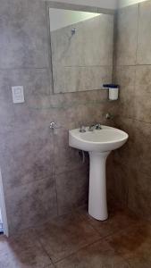 ein Badezimmer mit Waschbecken und Spiegel in der Unterkunft Las Acacias suites in San Lorenzo + 6 Fotos