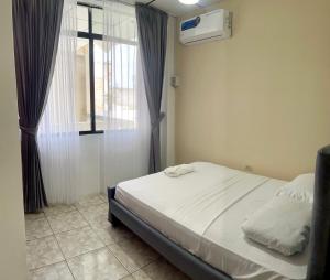 a bedroom with a bed and a window with a air conditioner at Moderno, grande, amplia vista, parqueo in Machala