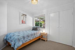a bedroom with a bed and a window at Marcoola Surfside Escape in Marcoola