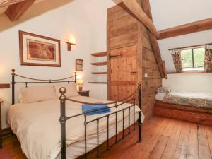 a bedroom with a bed and a wooden door at The Barn in Bicknoller