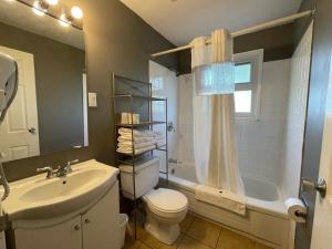 a bathroom with a sink and a toilet and a tub at Diplomat Motel in Nanaimo +14 photos