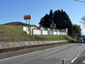 a road with a sign on the side of a hill at ホテルZERO in Tanigashira