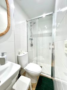 een witte badkamer met een toilet en een douche bij Fantástica Casa Rural en Castrillo Mota de Judíos in Burgos