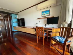 Camera con scrivania, TV e sedie. di Studio Blue Moana - Private apartment with sea view a Papeete