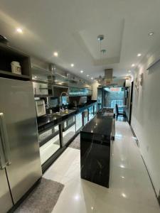 a large kitchen with a large stainless steel refrigerator at Casa de luxo c/piscina 4 quartos 2 banheiras. in Rio de Janeiro