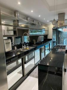 a large kitchen with black counter tops and appliances at Casa de luxo c/piscina 4 quartos 2 banheiras. in Rio de Janeiro +20 photos