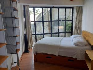 1 dormitorio con cama y ventana grande en Elmar hostal en Bacalar
