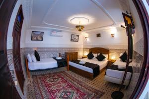 Un pat sau paturi într-o cameră la Dar Amir Fez