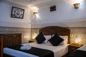 フェズにあるDar Amir Fezのホテルルーム ベッド2台&ランプ2つ付