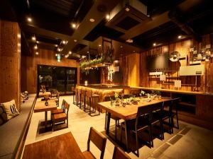 een restaurant met houten tafels en stoelen en een bar bij Focus Kuramae in Tokyo