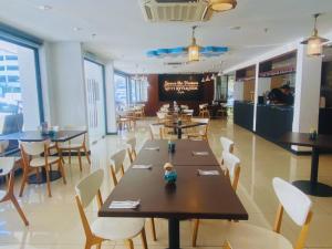 a dining room with tables and chairs in a restaurant at Oceania Hotel in Kota Kinabalu
