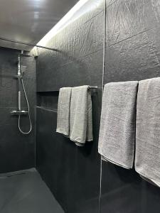 baño con toallas blancas colgadas en la pared en Apartamento em Cascais, en Cascais