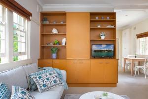 ein Wohnzimmer mit orangefarbener Wand in der Unterkunft Chic Apartment with Sun Lounge Near Manly Beach in Sydney