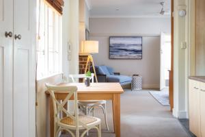 ein Wohnzimmer mit einem Tisch und Stühlen in der Unterkunft Chic Apartment with Sun Lounge Near Manly Beach in Sydney