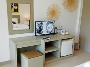 a dressing table in a bedroom with a mirror at Ampha Place Hotel in Mae Nam