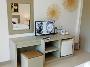 einen Schminktisch in einem Schlafzimmer mit einem Spiegel in der Unterkunft Ampha Place Hotel in Mae Nam
