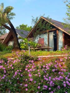 a house with a bunch of flowers in front of it at Đồi Gió Hú Homestay & Coffee - Măng Đen in Kon Tum