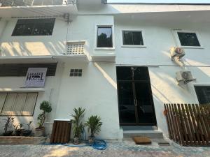 a white house with a sign on the side of it at Ladakul hostel (ลดากุลโฮสเทล) in Chom Thong