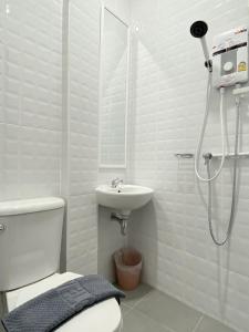 a bathroom with a shower and a toilet and a sink at Ladakul hostel (ลดากุลโฮสเทล) in Chom Thong