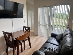a living room with a leather couch and a table at Country Inn in Pokeno