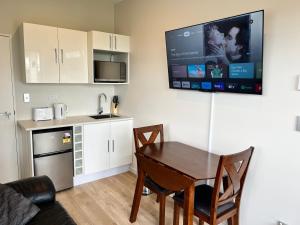 a kitchen and dining room with a table and a tv at Country Inn in Pokeno