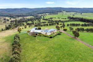 una vista aérea de una casa en un campo en IRONBARK FARM Farmhouse on 52 acres in the scenic Yarra Valley, en Glenburn