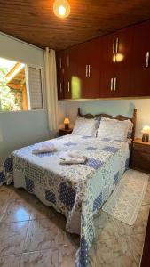 Casa da Roça في جونسالفيس: غرفة نوم بسرير وبطانية زرقاء وبيضاء