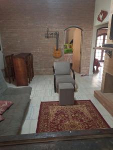 ラゴイーニャにあるAconchegante Sítio em Lagoinha SPのリビングルーム(ソファ、椅子、ギター付)