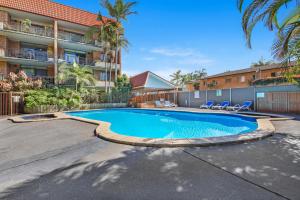a swimming pool in front of a apartment building at Hawaiian Gardens 22 in Coffs Harbour