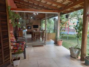 ラゴイーニャにあるAconchegante Sítio em Lagoinha SPのテーブルと椅子が置かれた網戸付きのポーチのある温室