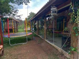 ラゴイーニャにあるAconchegante Sítio em Lagoinha SPのトランポリンのある遊び場のある家