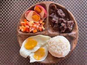 une plaque de denrées alimentaires contenant des œufs, du riz et de la viande dans l'établissement Tabularasa - T Luxury Boutique, à New Agutaya